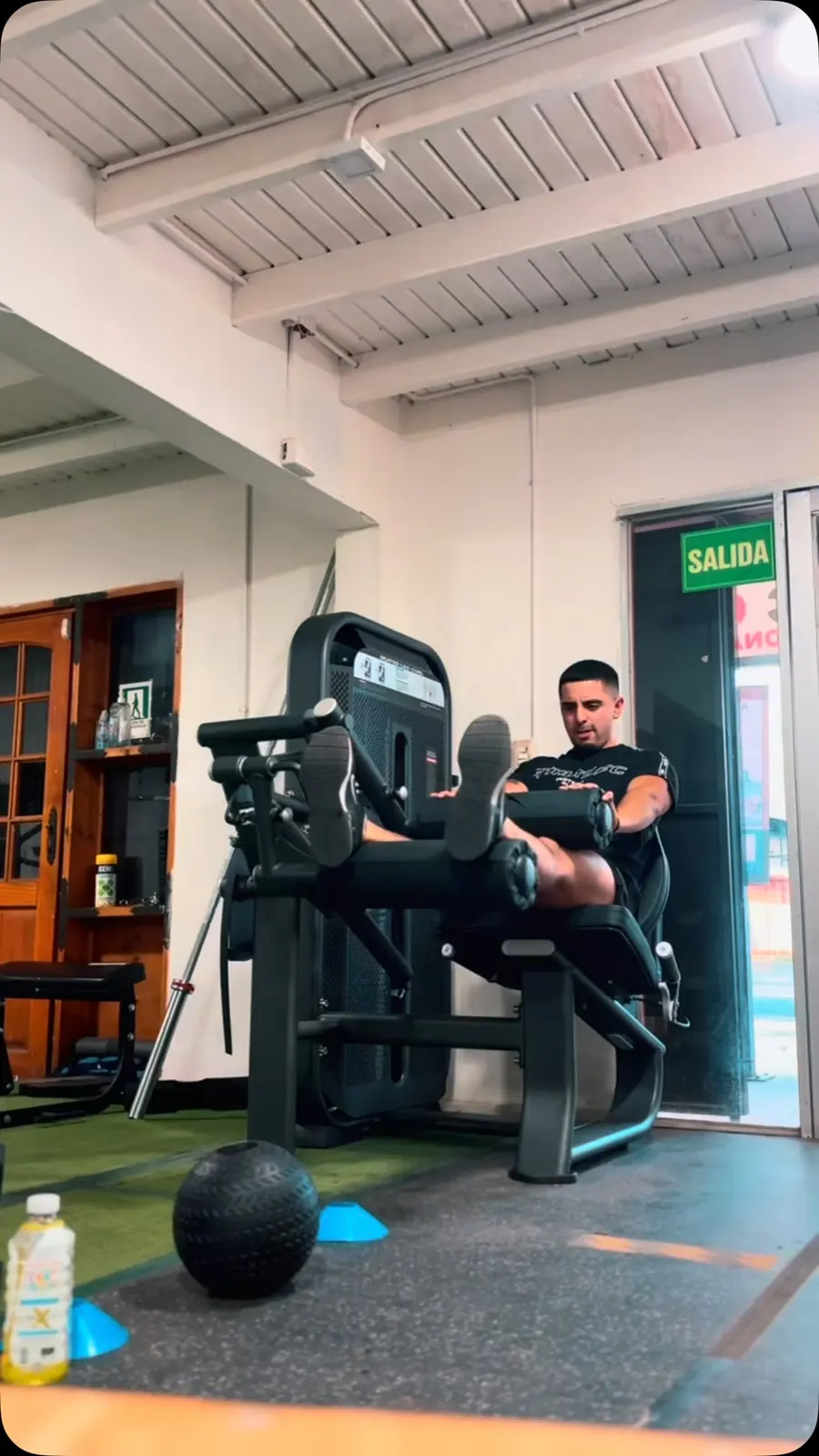 Persona usando la máquina de extensión de piernas
